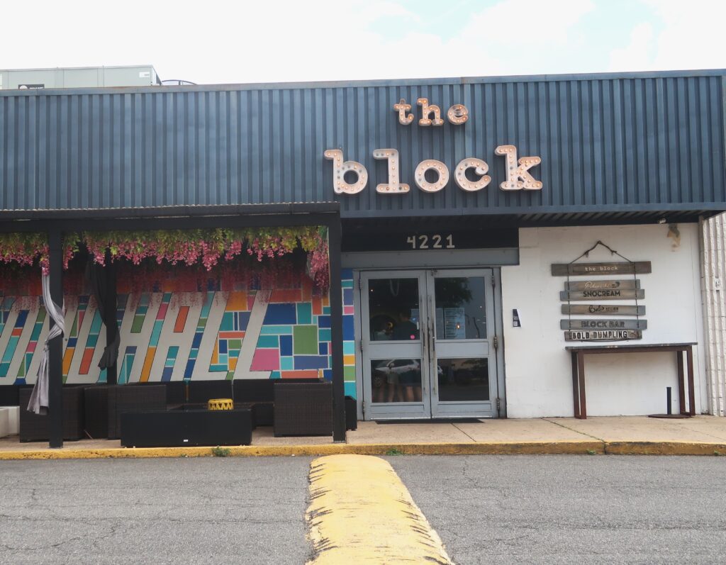 Mặt tiền cũ của The Block tại 4221 John Marr Drive, với biển hiệu phía trên lối vào và bức tranh tường nhiều màu sắc bên cạnh cửa.